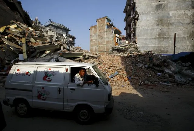 Light illuminates a man driving a vehicle past collapsed houses, a month after the April 25 earthquake in Kathmandu, Nepal May 25, 2015. (Photo by Navesh Chitrakar/Reuters)