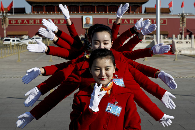 In this Sunday, March 5, 2017 photo, hospitality staff pose for photos on Tiananmen Square during the National People's Congress held at the Great Hall of the People in Beijing. (Photo by Andy Wong/AP Photo)