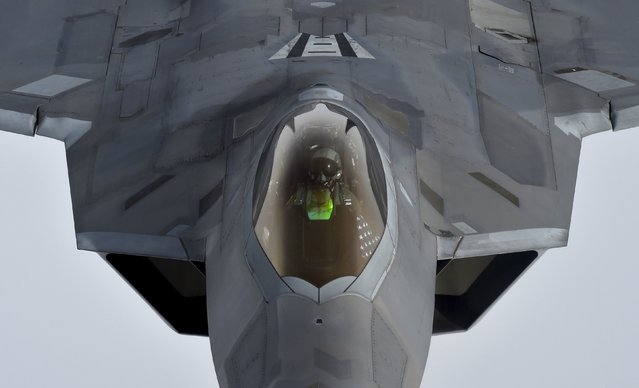 A pilot looks up from a U.S. F-22 Raptor fighter as it prepares to refuel in mid-air with a KC-135 refuelling plane over European airspace during a flight to Britain from Mihail Kogalniceanu air base in Romania April 25, 2016. (Photo by Toby Melville/Reuters)