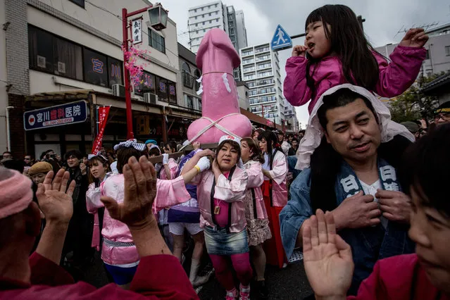 A large pink phallic-shaped “Mikoshi” is paraded through the streets during Kanamara Matsuri (Festival of the Steel Phallus), held each year on the first Sunday of April in Kawasaki, Japan, on April 6, 2014. The pen*s is the central theme of the festival, focused at the local pen*s-venerating shrine which was once frequented by prostitutes who came to pray for business prosperity and protection against sexually transmitted diseases. (Photo by Chris McGrath/Getty Images)