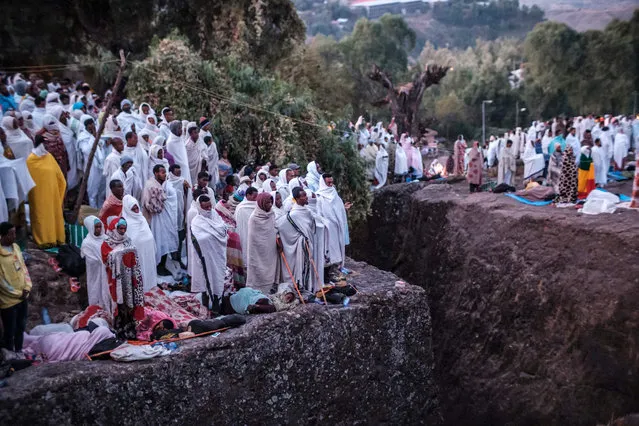 Pilgrims attend the celebration of Genna, the Ethiopian Orthodox Christmas, at Saint Mary's Church, in Lalibela, 645 kilometres (400 miles) north of Addis Ababa, in the Amhara region bordering the northern region of Tigray on January 7, 2022. Just weeks ago, the UNESCO-listed site and its astonishing houses of worship were under rebel control, Lalibela having changed hands once again as Ethiopia's war dragged into a second brutal and unpredictable year. But with the holy site and its 12th-century icons retaken by government forces in late December, Hailu joined tens of thousands of devotees flocking to Lalibela to mark the day for orthodox Christmas. (Photo by Eduardo Soteras/AFP Photo)