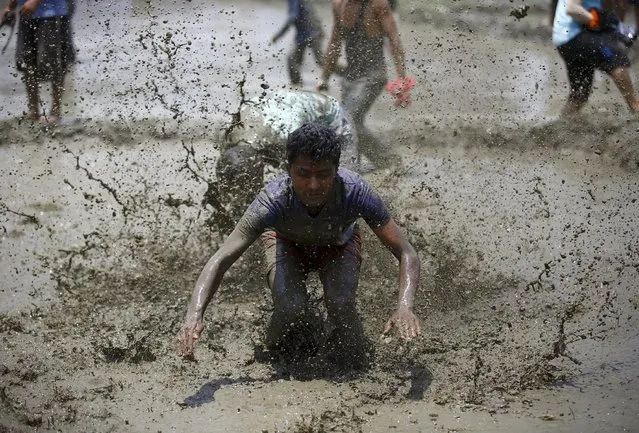 A man falls while playing in the mud during the Asar Pandhra festival in Pokhara valley, west of Nepal's capital Kathmandu, June 30, 2015. (Photo by Navesh Chitrakar/Reuters)