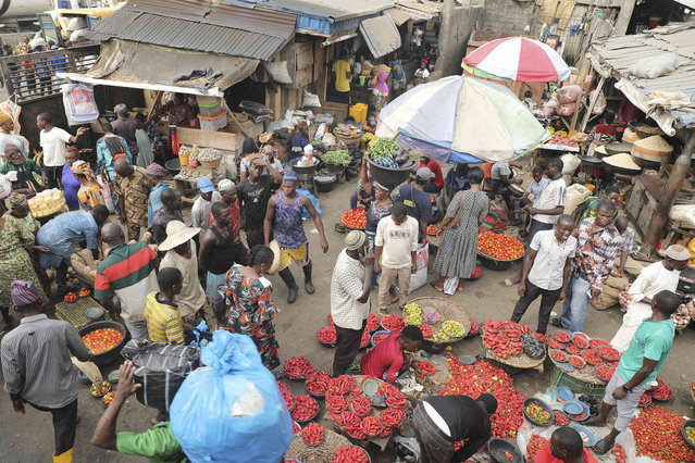 Pedestrians shop for pepper and other food items at the Mile 12 Market in Lagos, Nigeria, Friday, February 16, 2024. Nigerians are facing one of the West African nation's worst economic crises in as many years triggered by a surging inflation rate which follows monetary policies that have dipped the local currency to an all-time low against the dollar, provoking anger and protests across the country. (Photo by Mansur Ibrahim/AP Photo)
