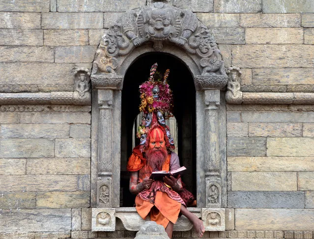 A Hindu Sadhu (holy man) sits on the premises of the Pashupatinath temple in Kathmandu, Nepal on July 15, 2019. Dozens of sadhus live around the temple devoting their life to Lord Shiva, the Hindu god of destruction. (Photo by Prakash Mathema/AFP Photo)