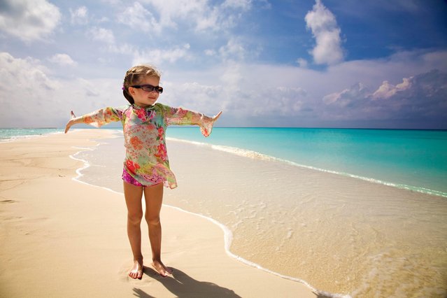 A little girl standing on top of a sandy beach, fullbody photo. (Photo by iStockPhoto)