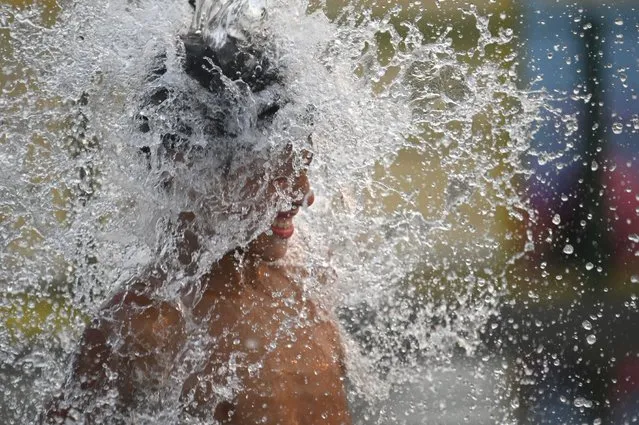 A child cools off amid a summer heat wave in Buenos Aires, Argentina, Friday, January 14, 2022. (Photo by Mario De Fina/AP Photo)