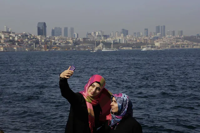 A mother and daughter take photos from a mobile phone as they enjoy the view of Bosphorus sea in Istanbul, Turkey, on Sunday, April 16, 2017. Turkish voters were casting their ballots Sunday in a historic referendum on whether to approve constitutional reforms that would greatly expand the powers of Erdogan. (Photo by Petros Karadjias/AP Photo)
