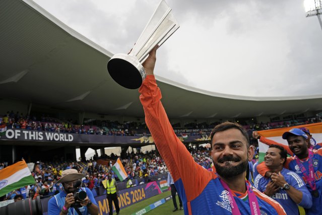 India's Virat Kohli carries the winners' trophy as he celebrates after India won the ICC Men's T20 World Cup final cricket match against South Africa at Kensington Oval in Bridgetown, Barbados, Saturday, June 29, 2024. (Photo by Ramon Espinosa/AP Photo)