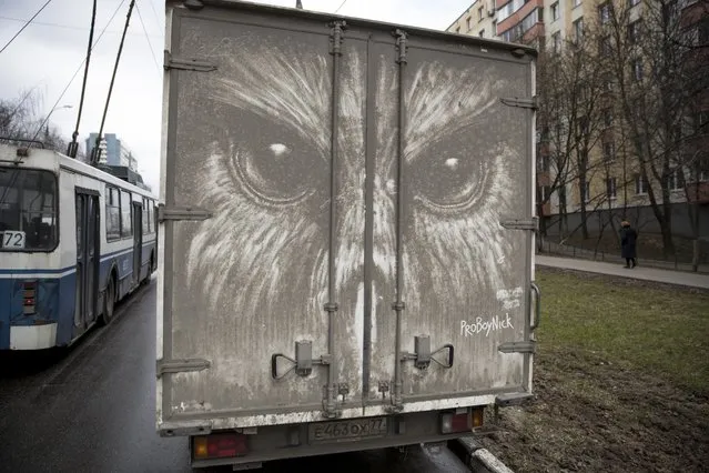 In this photo taken on Saturday, April 22, 2017, an owl is drawn on a muddy back of a truck by artist Nikita Golubev in Moscow, Russia. (Photo by Pavel Golovkin/AP Photo)
