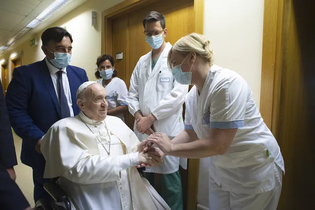 Pope Francis is greeted by hospital staff as he sits in a wheelchair inside the Agostino Gemelli Polyclinic in Rome, Sunday, July 11, 2021, where he was hospitalized for intestine surgery. (Photo by Vatican Media via AP Photo)