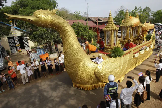 A chariot carrying a golden urn makes its way during a procession in Oudong, Kandal province, northwest of Phnom Penh, Cambodia, Friday, May 20, 2016. Thousands of Cambodians joined a procession to return what they believe are Buddha's relics to a mountain-top shrine from where they were stolen three years ago. (Photo by Heng Sinith/AP Photo)