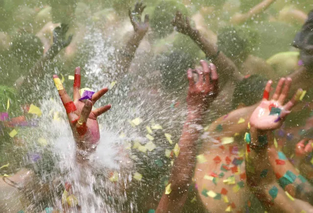 People celebrate Holi, the Hindu festival of colors, in Prayagraj, in the northern Indian state of Uttar Pradesh, India, India, Saturday, March 19, 2022. The festival, a celebration of warm weather, good harvests and the defeat of evil, brings out millions of people to throw powder at one another and play with water balloons and squirt guns. (Photo by Rajesh Kumar Singh/AP Photo)