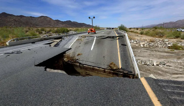 Damage is seen from a washed-out bridge near the town of Desert Center along Interstate 10 in Southern California, Monday, July 20, 2015. All traffic along one of the major highways connecting California and Arizona was blocked indefinitely when the bridge over a desert wash collapsed during a major storm, and the roadway in the opposite direction sustained severe damage. (Photo by Nick Ut/AP Photo)
