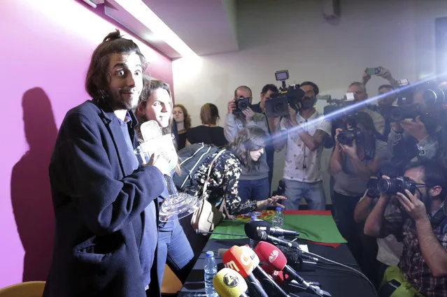 Salvador Sobral, left, and his sister Luisa Sobral, are lit by a camera flash, as they arrive for a news conference holding the Eurovision award, at the Lisbon airport, Sunday, May 14 2017, after winning the Final of the Eurovision Song Contest with his song “Amar pelos dois”, in Kiev, Ukraine, Saturday. (Photo by Armando Franca/AP Photo)