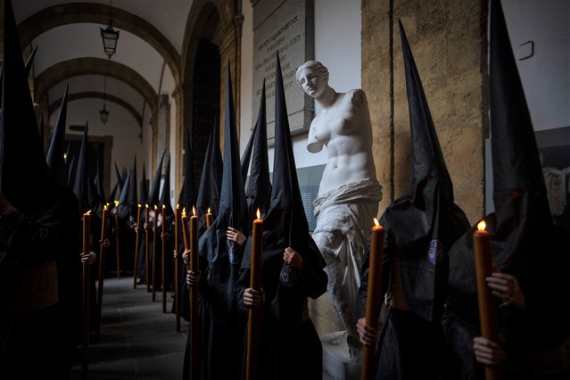 Penitents of “Los Estudiantes” brotherhood gather in one of the courtyards of the University of Seville before starting the procession, Spain, Tuesday, April 4, 2023. Hundreds of processions take place throughout Spain during the Easter Holy Week. (Photo by Emilio Morenatti/AP Photo)