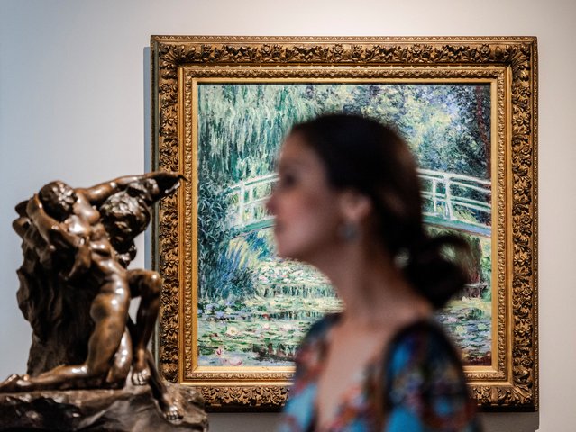 A woman walks past the painting “White Water Lilies” by Claude Monet during the “Impressionists instead of heat” campaign, which offers free admission to the Gallery of 19th and 20th Century European and American Art of the State Pushkin Museum in the hottest daytime hours, in Moscow, Russia on July 17, 2024. (Photo by Maxim Shemetov/Reuters)