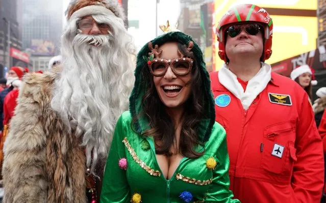 Revellers gather for the start of the Annual SantaCon Bar Crawl at Father Duffy Square, a section of Times Square, on December 14, 2019, in New York. SantaCon is an event where people make donations to charitable causes and dress up in holiday costumes and visit bars around the city. (Photo by TImothy A. Clary/AFP Photo)
