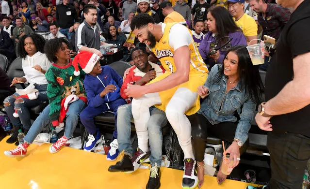 Anthony Davis of the Los Angeles Lakers lands on Kevin Hart at the end of the first half of a basketball game between the Los Angeles Lakers and the Los Angeles Clippers as his kids Heaven Hart and Hendrix Hart and wife Eniko Parrish look on at Staples Center on December 25, 2019 in Los Angeles, California. (Photo by Allen Berezovsky/Getty Images)