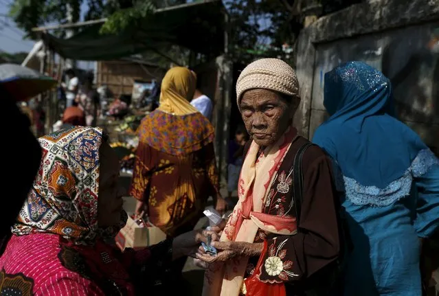 A stallholder passes back change to her colleague at a vegetable market near Duri train station in Jakarta, Indonesia August 3, 2015. (Photo by Reuters/Beawiharta)