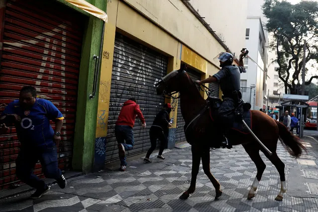 Riot police, holding a sword, clash with members of Brazil's Movimento dos Sem-Teto (Roofless Movement) during a protest against President Michel Temer's proposed economic reforms in Sao Paulo, Brazil June 30, 2017. (Photo by Nacho Doce/Reuters)