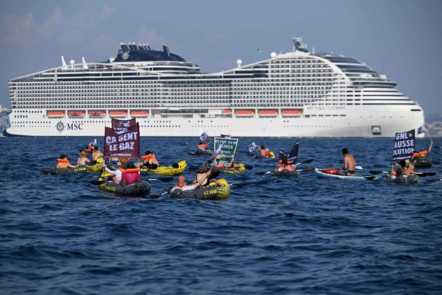 Activists from the “Stop croisieres” NGO display a banner on a sailing ship during a demonstration against cruise ships as the MSC World Europa cruise ship leaves Marseille's harbour, southern France, on June 17, 2023. (Photo by Nicolas Tucat/AFP Photo)