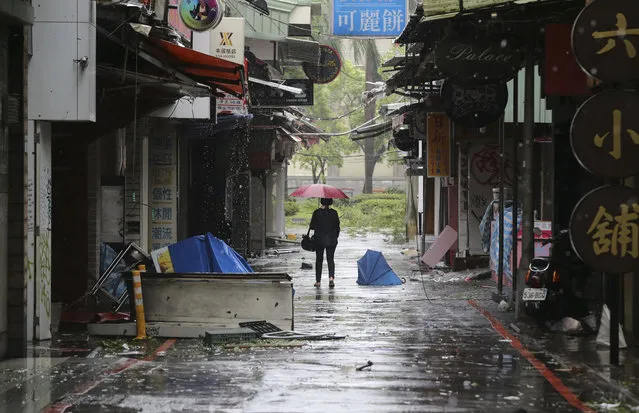 A woman walks down a back alley filled with debris from Typhoon Soudelor in Taipei, Taiwan, Saturday, August 8, 2015. (Photo by Wally Santana/AP Photo)