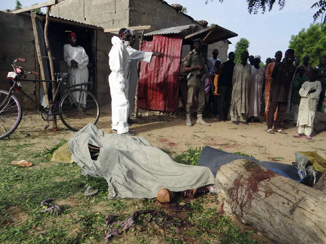 People mourn over the bodies of suicide bomb attack victims in a village near Maiduguri, Nigeria, Wednesday, July 12, 2017. Four Boko Haram suicide bombers killed over a dozen people in a series of attacks that targeted a civilian self-defense force and the people who gathered to mourn their deaths, police in Nigeria said Wednesday. It was the deadliest attack in months in the northeastern city of Maiduguri, the birthplace of Boko Haram's eight-year insurgency. (Photo by Jossy Ola/AP Photo)