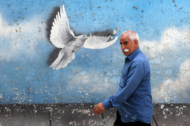 An Iranian man walks past a wall painting of a peace bird in a street in Tehran, Iran, 19 August 2024. Tension remains high between Iran and Israel since late Hamas leader Ismail Haniyeh was killed in Tehran on 31 July 2024, as Iran's leader Ayatollah Khamenei vowed for a 'harsh punishment' against Israel in retaliation over the killing of Haniyeh. The US and EU administrations asked Iran not to attack Israel as peace talks between Hamas and Israel are going on. (Photo by Abedin Taherkenareh/EPA/EFE)