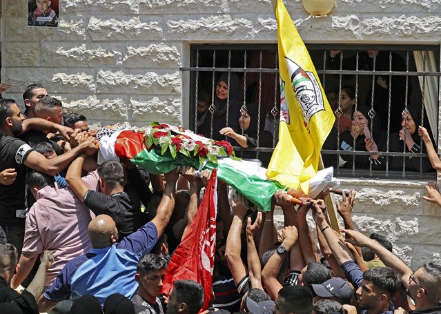 Palestinian mourners carry the body of 17-year-old Odeh Odeh, who was hit in the chest the day before by what the Palestinian health ministry said was an Israeli bullet, during his funeral in the village of Al-Madiya on June 3, 2022. The Israeli security forces have stepped up their operations in the West Bank in recent months, carrying out almost daily raids to arrest suspects after a spate of deadly attacks inside Israel. (Photo by Abbas Momani/AFP Photo)