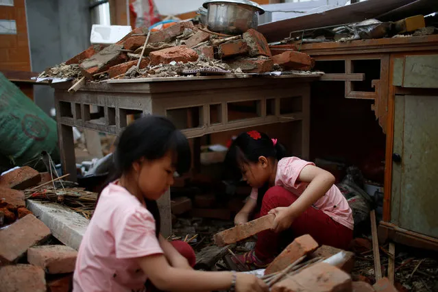 Twins look for belongings at their damaged house after a tornado hit Funing on Thursday, in Yancheng, Jiangsu province, June 24, 2016. (Photo by Aly Song/Reuters)