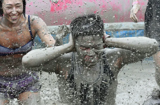 A man takes part in the Boryeong Mud Festival at Daecheon Beach in Boryeong, South Korea, Friday, July 18, 2014. The annual mud festival features mud wrestling and mud sliding. (Photo by Ahn Young-joon/AP Photo)