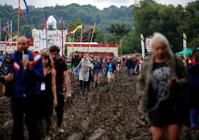 Revellers walk in the mud at Worthy Farm in Somerset during the Glastonbury Festival, Britain, June 26, 2016. (Photo by Stoyan Nenov/Reuters)