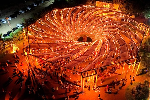 An aerial view shows revellers wearing traditional clothes as they dance at a “Garba” during the Hindu festival of Navratri, in the outskirts of Ahmedabad on October 9, 2024. (Photo by Sam Panthaky/AFP Photo)