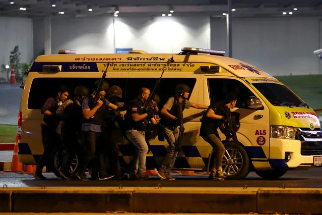 Thai security forces take cover behind an ambulance as they chase a shooter hidden in a shopping mall after a mass shooting in front of the Terminal 21, in Nakhon Ratchasima, Thailand on February 9, 2020. (Photo by Athit Perawongmetha/Reuters)