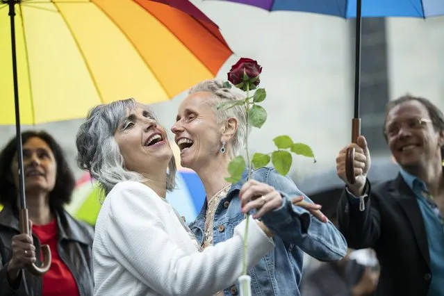 Annett Babinsky (C) and Laura Suarez (2-L) embrace after marrying at the registry office in Zurich, Switzerland, 01 July 2022. Following a referendum in fall 2021 that ended in favor of a “Marriage For All”, same sеx couples since 01 July 2022 for the first time are allowed to officially marry in Switzerland. (Photo by Ennio Leanza/EPA/EFE)