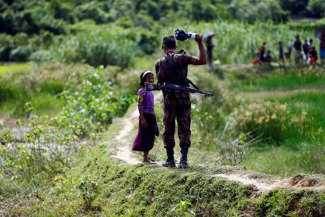 A member of Border Guard Bangladesh (BGB) tells a Rohingya girl not to come on Bangladesh side, in Cox’s Bazar, Bangladesh, August 27, 2017. (Photo by Mohammad Ponir Hossain/Reuters)