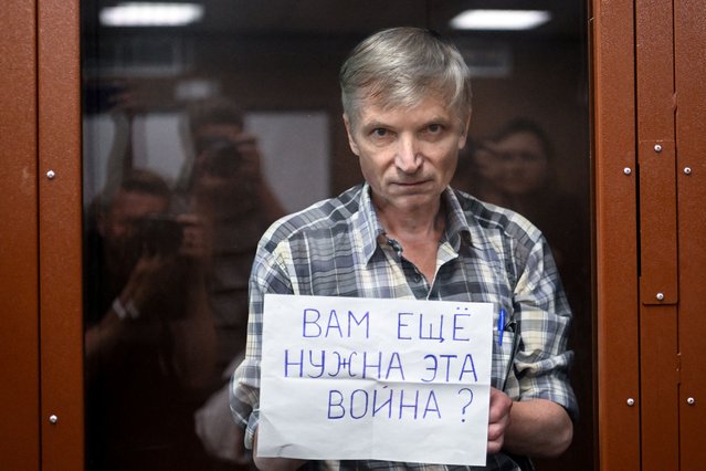 Moscow city deputy Alexei Gorinov, accused of spreading “knowingly false information” about the Russian army fighting in Ukraine, stands with a poster reading “Do you still need this war?” inside a glass cell during the vedict hearing in his trial at a courthouse in Moscow on July 8, 2022. (Photo by Kirill Kudryavtsev/AFP Photo)