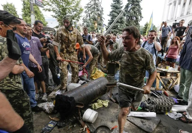 Protesters try to prevent municipal workers and volunteers from clearing away their tents at Independence Square in Kiev August 9, 2014. Tensions continued on Kiev's Independence Square, the scene of street protests that toppled a Moscow-backed president in February, as protesters still camped there clashed with city workers who tried to clear away their tents. (Photo by Konstantin Chernichkin/Reuters)