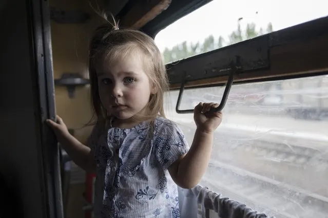 Internally displaced Kira from Toretsk stands inside a train heading to Dnipro, at the Pokrovsk train station, Donetsk region, eastern Ukraine, Friday, July 8, 2022. (Photo by Nariman El-Mofty/AP Photo)
