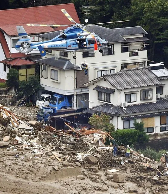 In this aerial photo, a survivor is lifted by a rescue helicopter from an area devastated by a massive landslide in Hiroshima, western Japan, Wednesday, August 20, 2014. (Photo by AP Photo/Kyodo News)