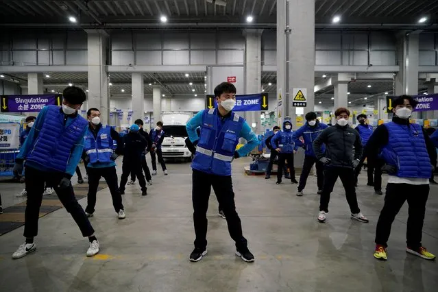 A delivery man for Coupang Jung Im-hong wearing a mask to prevent contracting the coronavirus, warms up before leaving to deliver packages in Incheon, South Korea, March 3, 2020. Picture taken on March 3, 2020. (Photo by Kim Hong-Ji/Reuters)