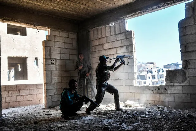 Members of the Syrian Democratic Forces fire their arms during a battle against Islamic State (IS) group jihadists to retake the central hospital of Raqa on the western frontline of the city on September 28, 2017. Syrian fighters backed by US special forces are battling to clear the last remaining Islamic State group jihadists holed up in their crumbling stronghold of Raqa. (Photo by Bulent Kilic/AFP Photo)