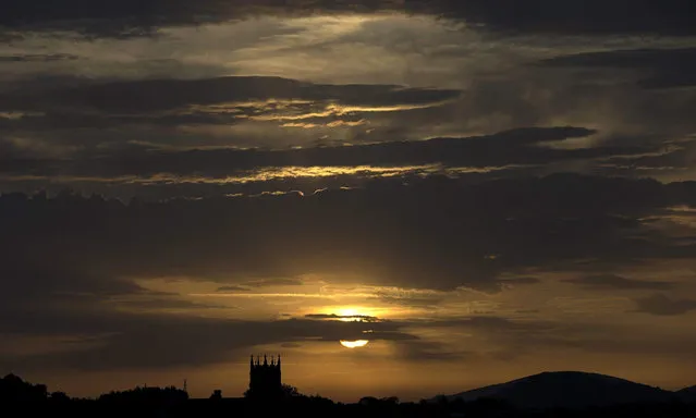 The Sun is seen rising behind Zorroaga Church in San Sebastian, northern Spain, 31 August 2015. Rain and bad weather returned to the north of the country after a week of high temperatures. (Photo by Javier Etxezarreta/EPA)