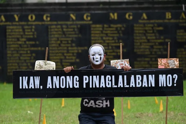 A masked activist looks on during a performance art to commemorate the International Day of the Disappeared at the Monument of Heroes in Quezon City, suburban Manila on August 30, 2022. (Photo by Jam Sta Rosa/AFP Photo)