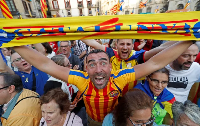 A man displays a scarf featuring an Estelada (Catalan separatist flag) design, as he reacts at Sant Jaume Square after the Catalan regional parliament declares independence from Spain in Barcelona, Spain October 27, 2017. (Photo by Yves Herman/Reuters)