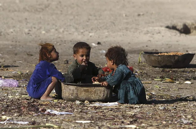 Afghan internal displaced refugee children eat food near their shelter at the outskirts of Kabul October 5, 2012. (Photo by Omar Sobhani/Reuters)