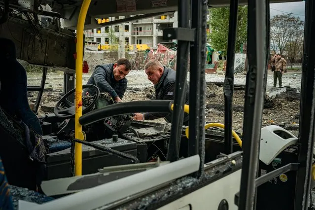 Investigators examine a destroyed bus, following a missile strike in Dnipro on October 10, 2022, amid Russia's invasion of Ukraine. The head of the Ukrainian military said that Russian forces launched at least 75 missiles at Ukraine on Monday morning, with fatal strikes targeting the capital Kyiv, and cities in the south and west. (Photo by Dimitar Dilkoff/AFP Photo)