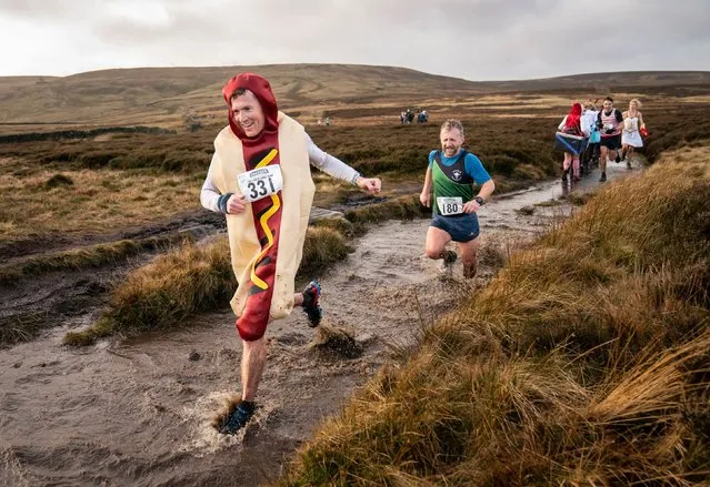 Competitors in fancy dress run across the Pennine tops near Haworth, West Yorkshire on Friday, December 31, 2021, in the annual Auld Lang Syne Fell race which attracts hundreds of runners every year. (Photo by Danny Lawson/PA Images via Getty Images)