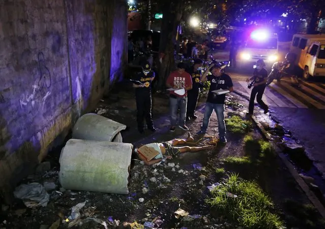 Filipino crime scene investigators inspect the body of a suspected drug dealer, who was shot dead by unidentified gunmen, found with a placard reading “Do not follow me, I'm a pusher”, at a street in Manila, Philippines, 19 August 2016. According to Police data which was submitted to a Senate investigation by Director General Ronald dela Rosa on 18 August, at least 665 people were slain during anti-drug police operations and 899 more deaths committed by still unknown killers, based on a tally from 01 July to 15 August. (Photo by Francis R. Malasig/EPA)