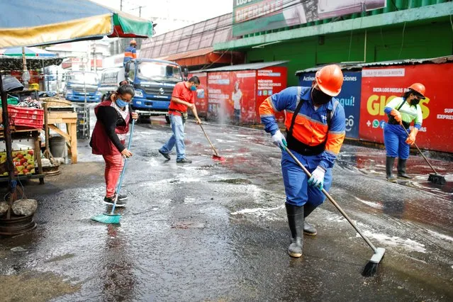 Street vendors and municipality workers clean a street to start serving customers as economy reopens after a three month closure, as the coronavirus disease (COVID-19) outbreak continues, in downtown San Salvador, El Salvador on June 18 2020. (Photo by Jose Cabezas/Reuters)